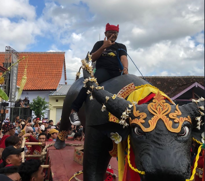 Ketua DPRD Banyuwangi sekaligus Ketua DPC PDI Perjuangan, I Made Cahyana Negara saat menaiki replika kerbau dalam tradisi adat Keboan Desa Aliyan