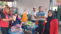 Sekretaris DPC PDI Perjuangan Banyuwangi,Ficky Septalinda (kanan) saat membagikan tumpeng HUT Megawati ke warga sekitar